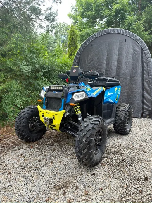 Niebiesko-żółty Polaris Scrambler przed warsztatem